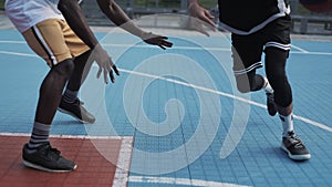 Close Up of Two Young Active Mixed Race Mens Legs Playing Basketball, Bouncing and Throwing ball, One on One at the