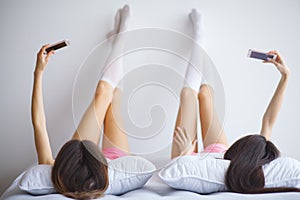 Close up of two young woman legs lying on the bed