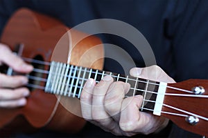 Close up ukulele fretboard in musician hands