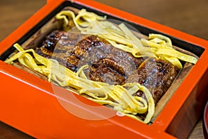 Close up Unagi don - Grill eel rice in red box .
