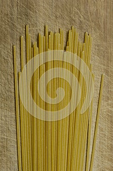 Close-up of Uncooked Spaghetti On A Scratched Wooden Board, Top View