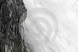 Close Up Underneath Big Waterfall and Dripping Cliff