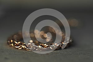 Close-up of unfinished bracelet on goldsmith table. Jewelry in the manufacturing process. Hand weave chain. Craft