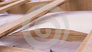 Close up of unfinished wooden roof of a new house at construction site with white protective cloth waving in the wind
