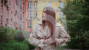 Close-up of unhappy business woman touching chest. Distressed young lady having panic attack in city street. Risk of