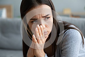 Close up unhappy young woman thinking about problems alone