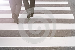 close-up on unidentified people legs crossing street