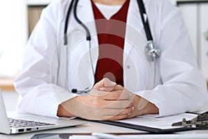 Close up of a unknown female doctor`s hands. Physician is ready to consult and halp patients