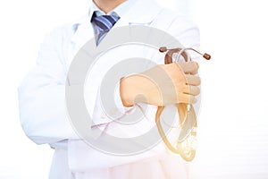 Close Up of Unknown male doctor standing straight while holding stethoscope. Medicine and health care concept