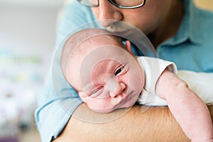 Close up, unrecognizable father holding his newborn baby son