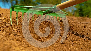 CLOSE UP Unrecognizable landscaper levelling a pile of soil before sowing plants