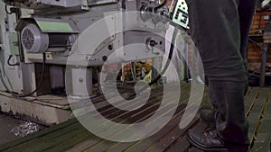 Close up of unrecognizable machine operator turning handle of machine while adjusting it. Stock footage. Side view of a
