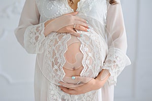 Close-up of unrecognizable pregnant woman with hands over tummy