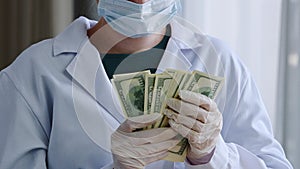 Close-up of unrecognizable woman doctor nurse in medical mask female surgeon wears latex gloves and white coat holds