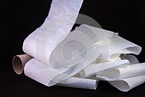 close up of an unrolling of toilet paper with the empty card at the side