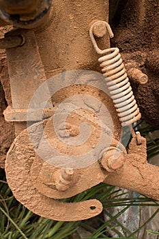 Close Up up of muddy engine component with tension spring on a light motorcycle in Asia