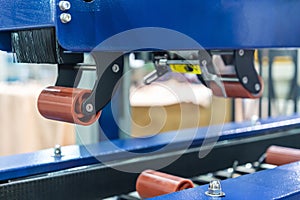Close up upper urethane rubber roller and brush of automatic box carton sealing machine by masking tape for commercial packing