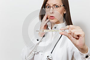 Close up upset doctor woman in medical gown with stethoscope, glasses. Focus on clinical thermometer with high fever