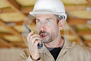 close up upset engineer holding walki talkie