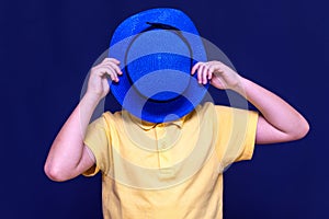 Close up of upset sun burned kid boy crying face hidden under hat