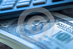 Close up US Dollar banknotes and calculator as symbol of profit and income. Selective focus