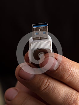Close-up of a usb flash drive in a manâ€™s hand