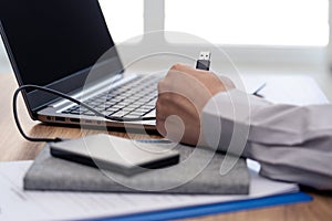 Close up USB plug in hand a man use cable with Hard drive External connect to laptop computer for transfer data work