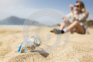 Close-up of a used discarded plastic bottle lying on the sand on the beach. Plastic environmental pollution with garbage