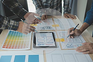 Close up ux developer and ui designer brainstorming about mobile app interface wireframe design on table with customer breif and