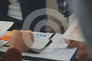 Close up ux developer and ui designer brainstorming about mobile app interface wireframe design on table with customer breif and