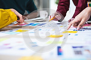 Close up ux developer and ui designer brainstorming about mobile app interface wireframe design on table with customer brief and c