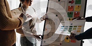 Close up ux developer and ui designer brainstorming about mobile app interface wireframe design on table with customer