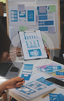 Close up ux developer and ui designer use augmented reality brainstorming about mobile app interface wireframe design on desk at