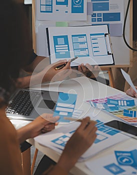 Close up ux developer and ui designer use augmented reality brainstorming about mobile app interface wireframe design on desk at