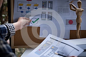 A close-up of an ux ui developer and an ui designer working on a mockup icon interface for a mobile app.