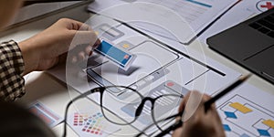 A close-up of an ux ui developer and an ui designer working on a mockup icon interface for a mobile app.