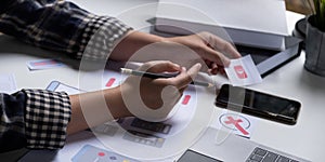 A close-up of an ux ui developer and an ui designer working on a mockup icon interface for a mobile app.