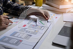 A close-up of an ux ui developer and an ui designer working on a mockup icon interface for a mobile app.