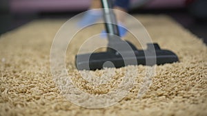 Close-up of vacuum cleaner sweeping dust from expensive rug, household hygiene