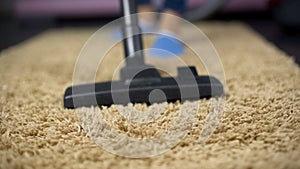 Close-up of vacuum cleaner sweeping dust from expensive rug, household hygiene
