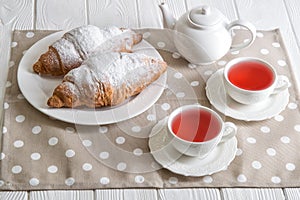 Close up. Valentine`s day celebration. Romantic breakfast for two. Freshly baked French croissants and berry tea in openwork cups