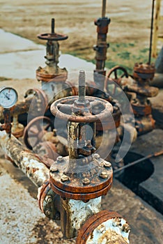 Close-Up Of Valve On Pipeline. Oil Or Gas Transportation With Gas Or Pipe Line Valves On Soil And Sunrise Background