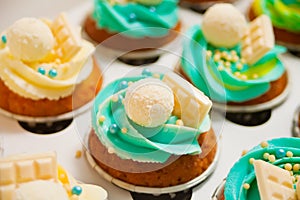 Close up vanilla cupcakes with varios cream cheese and candy in a paper box for gift photo