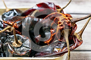 Close up of various dried Pasilla, Cascabel, Guajillo hot chili peppers. photo