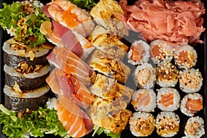 Close up of Various sushi set in black plastic delivery box. Top view