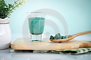 Close up a vegan blue spirulina smoothie and spirulina pills , a healthy superfood diet and detox nutrition concept