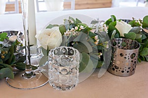 Close up veiw of wedding floral details. White candles,roses and eucalyptus.