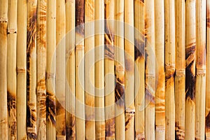 Close up vertical photo texture of brown and yellow colored bamboo mat