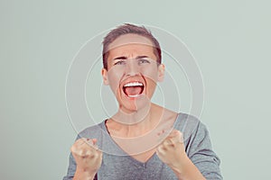 Close up very angry woman screaming in horror, grimace portrait. Stressed frustrated young lady having nervous breakdown isolated