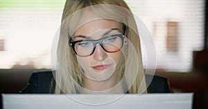 Close up of a very tired young woman working on a computer late into the night.